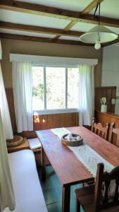 ein Esszimmer mit einem Holztisch und einem Fenster in der Unterkunft Los Alamos in San Carlos de Bariloche
