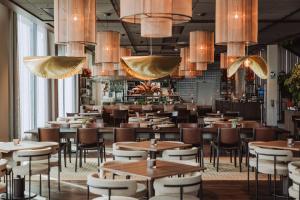 un ristorante con tavoli, sedie e lampadari di Clarion Hotel The Pier a Göteborg