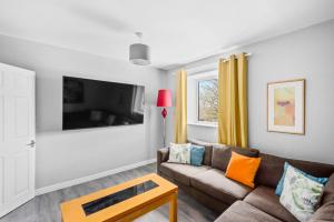a living room with a couch and a tv at Spacious 4 bed with Parking ideal base for work in Avonmouth