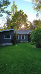 ein Haus mit einem grünen Rasen davor in der Unterkunft Los Alamos in San Carlos de Bariloche