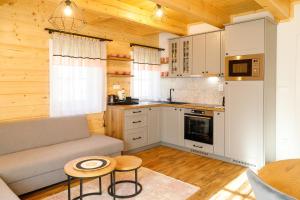 a kitchen with a couch and a table in a room at Chalupa Tri Koruny in Vígľaš