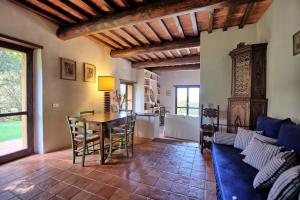 a living room with a table and a blue couch at Casale Argentario by PosarelliVillas in Porto Santo Stefano