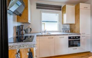 a kitchen with white cabinets and a window at Wieringen Waddenlodge in Den Oever