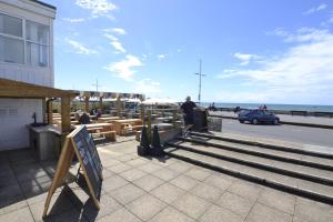 Un hombre de pie junto a un banco cerca de la playa. en Westpoint Dog Friendly Apartments, en West Bay 29 fotos más