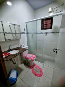 a bathroom with a shower and a toilet and a sink at Casa com piscina em Bertioga 700m da praia in Bertioga