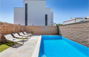 basen z leżakami przy ceglanej ścianie w obiekcie Awesome Home In Peroj With Sauna w mieście Peroj +20 zdjęć