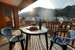 stół z butelką wina i 2 krzesłami na tarasie w obiekcie Andrea 7 by SMR Rauris Apartments - inc Spa and near Gondola w mieście Rauris