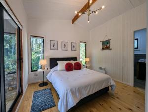 um quarto com uma cama com duas almofadas vermelhas em Casa del bosque em Catrico