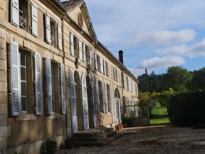 an old building with white shutters on it at Poliné, private and rustic Golf in Pavie