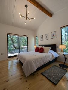 um quarto com uma cama com duas almofadas vermelhas em Casa del bosque em Catrico