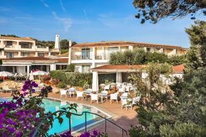 ośrodek z basenem, stołami i krzesłami w obiekcie Grand Hotel In Porto Cervo w mieście Porto Cervo