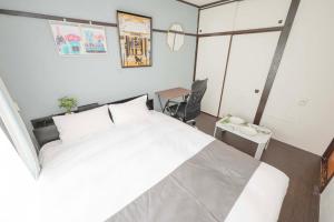 a bedroom with a large white bed and a desk at 渋谷駅徒歩6分!高速インターネット光回線 in Tokyo