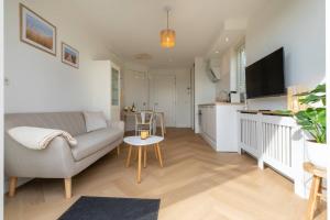 a living room with a couch and a table at Hello Zeeland - Appartement Kusthuys 2 - 2025 in Zoutelande