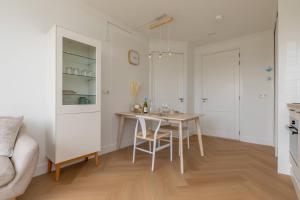 a kitchen with a table and chairs in a room at Hello Zeeland - Appartement Kusthuys 2 - 2025 in Zoutelande