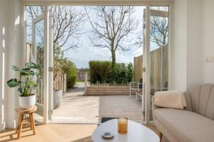 a living room with a couch and a table at Hello Zeeland - Appartement Kusthuys 2 - 2025 in Zoutelande