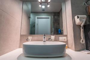 New Gudauri Studio near main Gondola lifts في غودواري: حمام مع حوض أمام مرآة +20 صورة