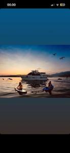 three people sitting in boats on the beach with a boat at Sail & Stay in Castillo de Sabinillas
