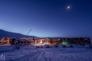 New Gudauri Studio near main Gondola lifts في غودواري: مجموعة من الخيام في الثلج في الليل