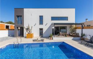 a villa with a swimming pool in front of a house at Villa Arcus in Pakoštane