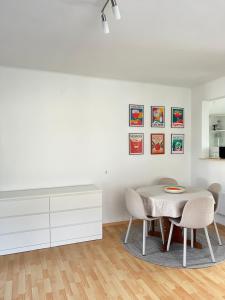 a white dining room with a table and chairs at Pipacs in Balatonszárszó