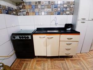 a kitchen with a black stove and a sink at Casa Próx.Aeroporto/10minutos do centro Curitiba in Curitiba +13 photos