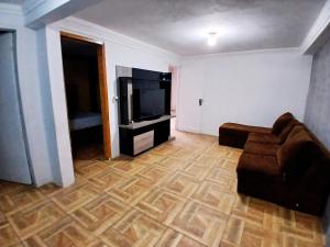 a living room with a couch and a flat screen tv at Casa Próx.Aeroporto/10minutos do centro Curitiba in Curitiba