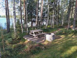 a wooden bench sitting on a boardwalk near the water at Katajaranta in Karvonen