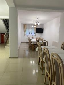 a dining room and living room with a table and chairs at Pensiunea Vătafu in Gura Râului