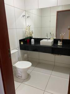 ein weißes Badezimmer mit Toilette und Waschbecken in der Unterkunft Casa pé na areia na praia de Antunes em Maragogi in Maragogi