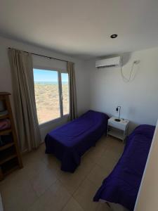 Un dormitorio con dos camas y una ventana. en Casa Chocón Medio Villa de Playa, en El Mangrullo