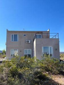 un edificio en una colina con arbustos delante de él en Casa Chocón Medio Villa de Playa, en El Mangrullo