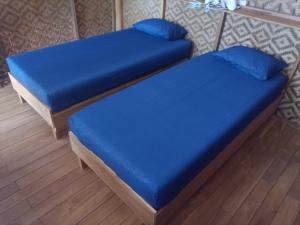 two beds with blue cushions in a room at SELAYAR TURTLE BAY in Barangbarang