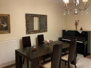 a dining room with a table and a piano at Full House Trikala Escape in Tríkala