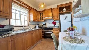 een keuken met een tafel en een witte koelkast bij Casa Maruca in Puntagorda