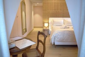a bedroom with a bed and a table and a mirror at Hôtel Restaurant Auprès d'Angèle in Marcillac-Vallon