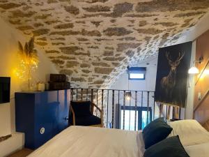 a bedroom with a bed and a stone ceiling at Eden de Thau 1ère ligne in Bouzigues