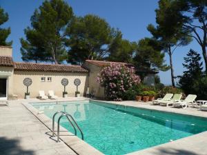 a swimming pool with chairs and a house at La rouvraie in Flayosc