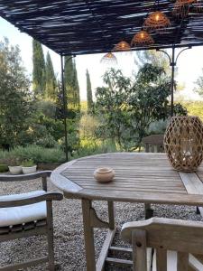 een houten picknicktafel met 2 stoelen en een parasol bij La rouvraie in Flayosc