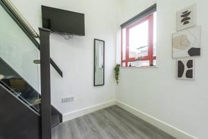 a white room with a flat screen tv on a wall at Studio in Central Reading- Next to Town Centre in Reading