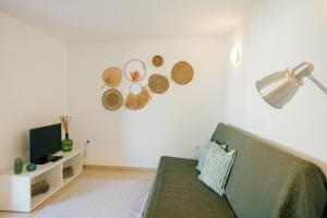 セジンブラにあるTree House - Casa Figueiraの緑のソファとテレビのあるリビングルーム