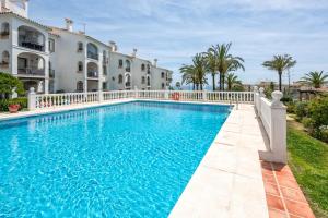 a swimming pool in front of a house at F04 Bahia Playa - Apartment in Mijas Costa