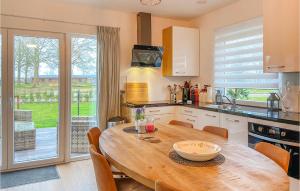 a kitchen with a wooden table and a large window at Kavel 13 in Den Oever