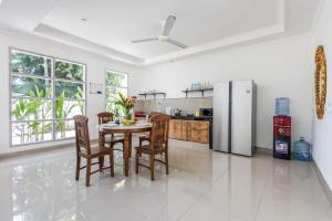 a kitchen with a table and chairs and a refrigerator at Villa Chunga-changa Double six in Seminyak