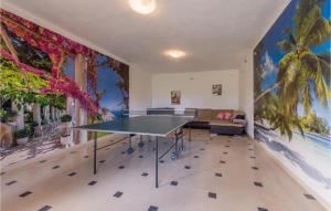 a ping pong table in a room with a palm tree mural at Amazing Home In Zadar in Zadar +36 photos