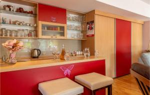 a kitchen with a red bar with two stools at Amazing Home In Zadar in Zadar