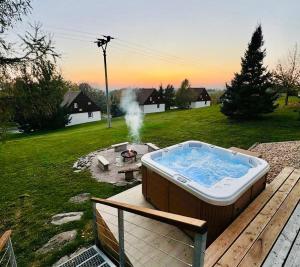 a hot tub sitting on a deck next to a fire pit at Čistá v Krkonoších - Chata Belmonda in Cerny Dul