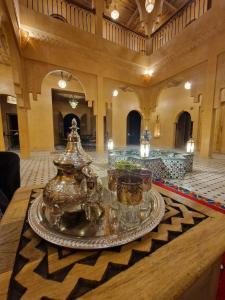 una grande hall con un tavolo con occhiali di Hotel Kasbah Riad Amnir a Mhamid