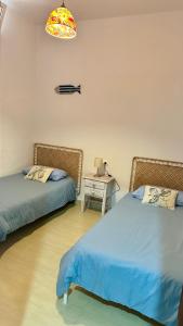 a room with two beds and a table with a lamp at Casa a 65 metros de la Playa in El Palmar
