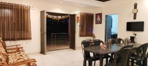a dining room with a table and chairs and a television at LaForesta By Mahabaleshwar Stay in Mahabaleshwar