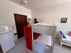 a small kitchen with a white refrigerator and a red freezer at Residence Casa Pineta in Principina a Mare